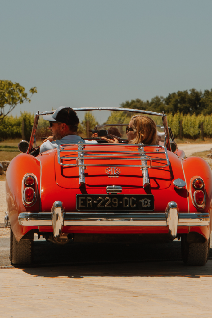 Couple en MG rouge décapotable