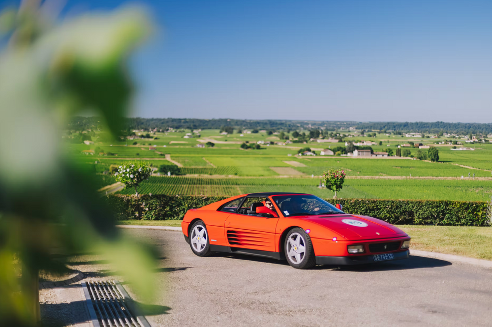 Ferrari rouge devant les vignes de Saint-Émilion